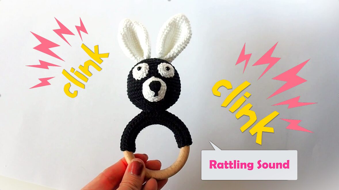 Hand Holding a Black Crochet Bunny Rattle Teether with comics manner "click" sounds are besides a toy as a rattling sounds