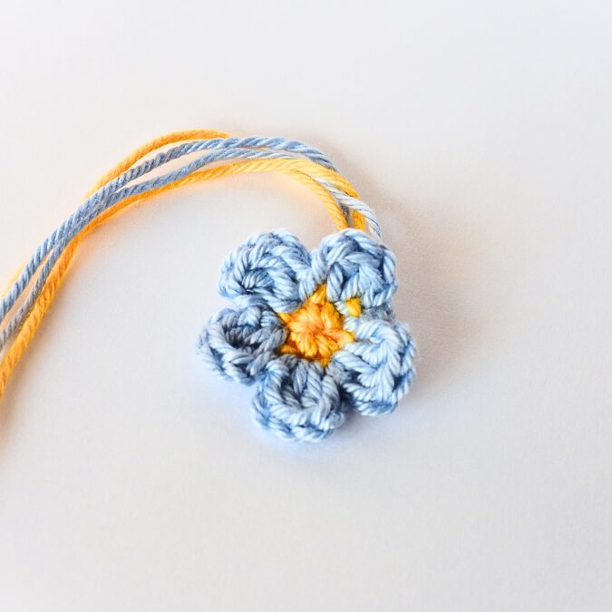 Crochet Forget-me-not flower in bright yellow center and light blue 5 petals